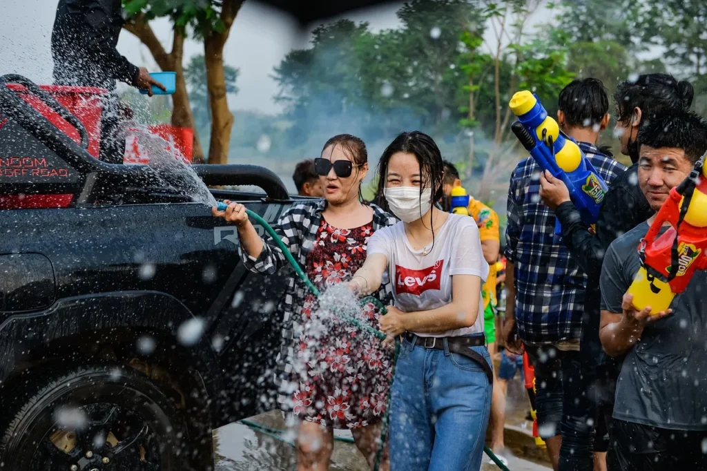 A group of people splashing water from hose and water gun during the Songkran Festival in Thailand