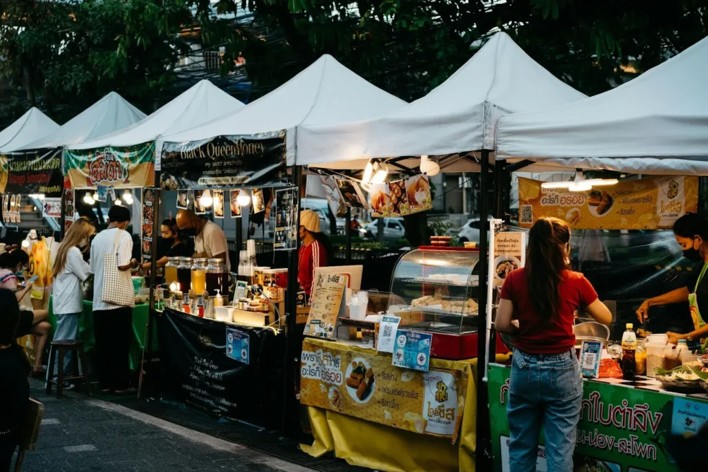 A row of street food vendors selling various Thai delicacies 