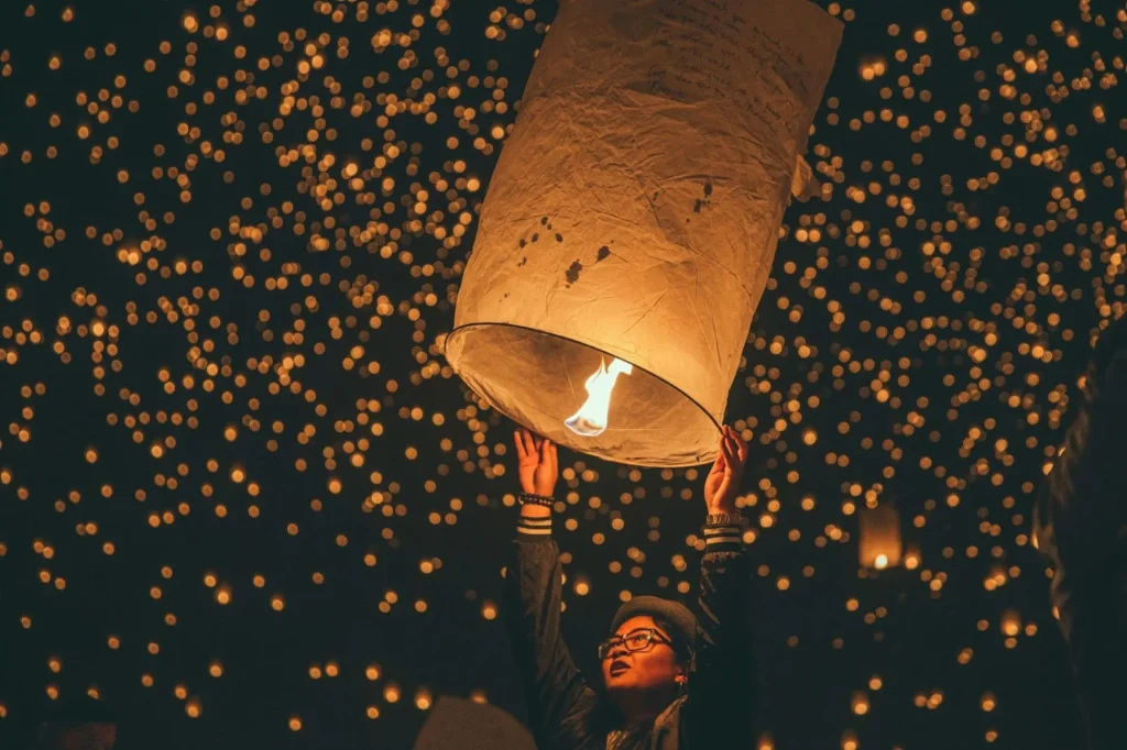 A woman holding a paper lantern during the Yi Peng Festival in Thailand